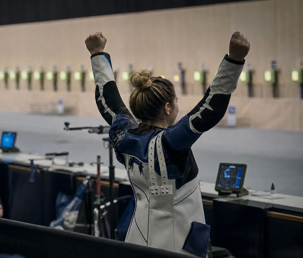 Precision-rifle athlete celebrating a winning result at an indoor shooting event